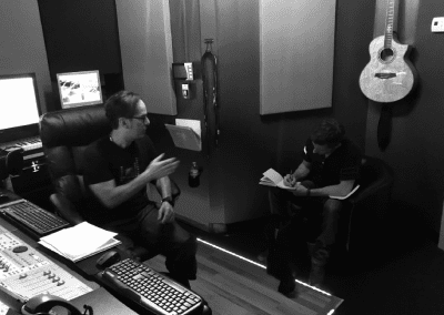 Two men are discussing beside them there is guitar